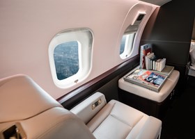 Seats facing each other next to a window on the VistaJet