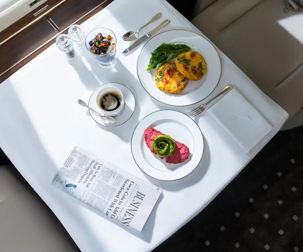 VistaJet airhostess serving guests signature seasonal dishes