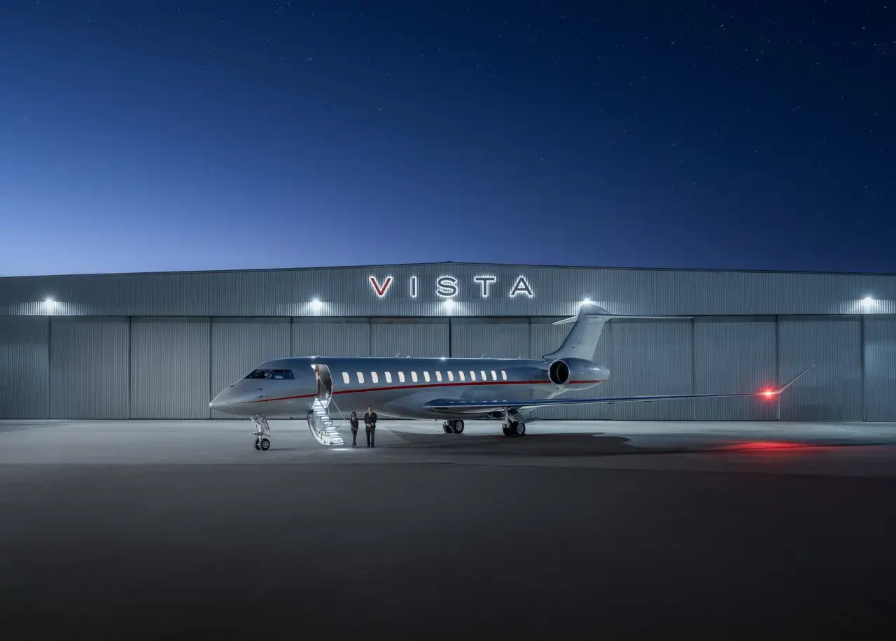 VIstaJet plane outside of Vista hanger at night-time
