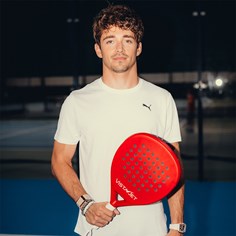 Charles Leclerc on court holding a VistaJet themed padel